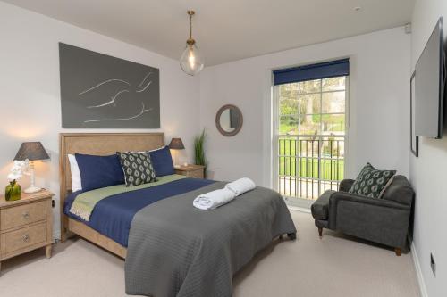 a bedroom with a bed and a chair and a window at Bath Penthouse with amazing views and lift access in Bath
