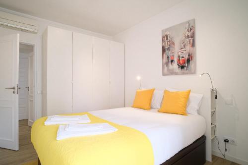 1 dormitorio con 1 cama grande con almohadas amarillas en The Plaza Flat, en Lisboa