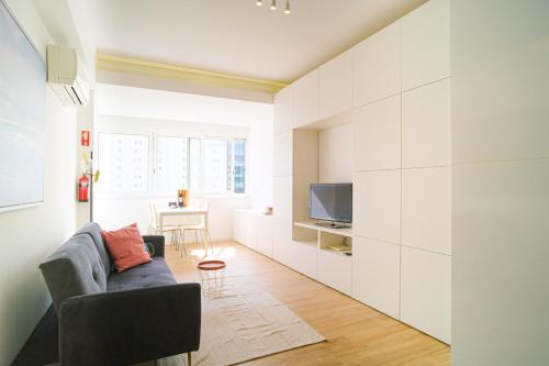a living room with a couch and a tv at The Plaza Flat in Lisbon