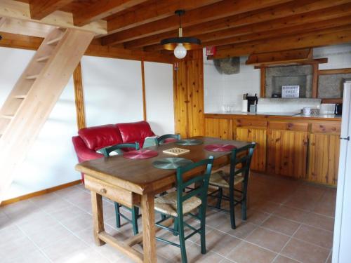 a kitchen and dining room with a wooden table and chairs at La ch'tiote meizou in Mazet-Saint-Voy