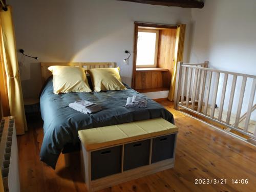 a bed in a room with a wooden floor at La ch'tiote meizou in Mazet-Saint-Voy