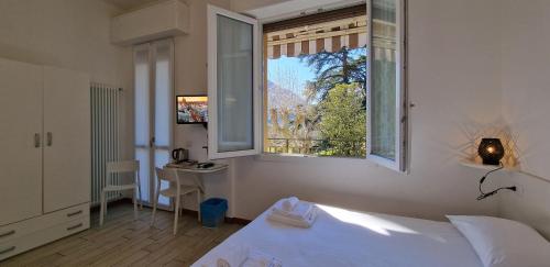 una camera con un letto bianco e una finestra di Hotel Beretta a Perledo
