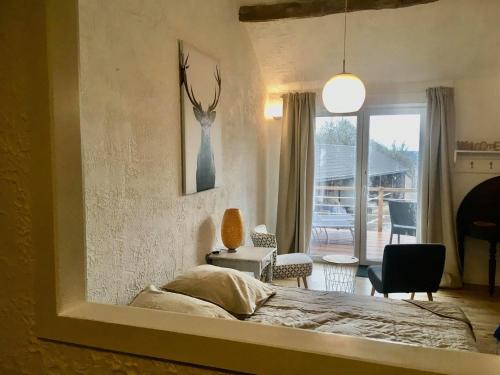 1 dormitorio con 1 cama con una foto de un ciervo en la pared en La Ferme De Durbuy, en Durbuy