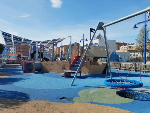 un parque infantil vacío con un tobogán y un columpio en Port 1, en Tarragona