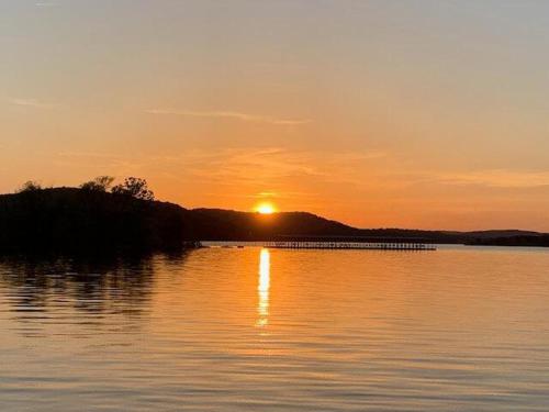 a sunset over a body of water with the sun setting at Lakeside Landing Suite in Hollister