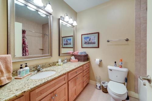 a bathroom with a sink and a toilet and a mirror at Cozy Birchwood Condo on Tagalong Golf Course! in Birchwood