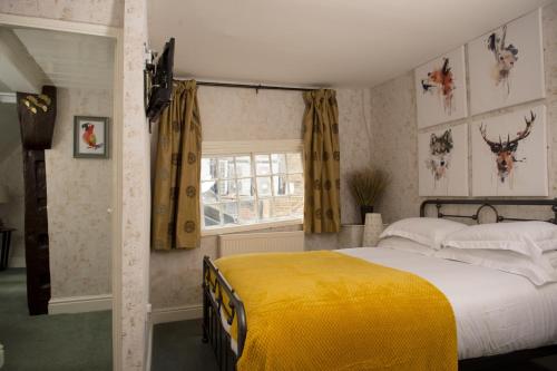 a bedroom with a bed with a yellow blanket at The Sun Hotel in Canterbury