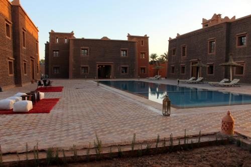 a courtyard with a swimming pool in a building at Bab Rimal - Desert Hotel in M'hamid El Ghizlane in Mhamid