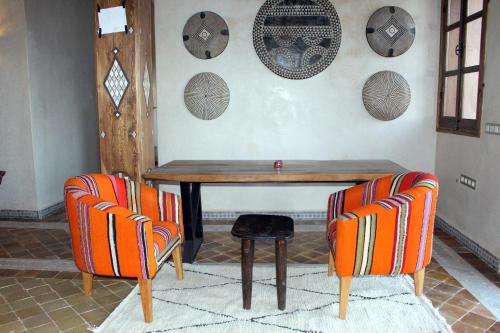 a dining room with a table and two chairs at Bab Rimal - Desert Hotel in M'hamid El Ghizlane in Mhamid