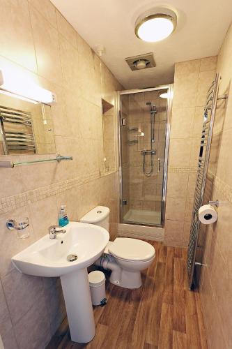 a bathroom with a sink and a toilet and a shower at Camberley House in Sheringham
