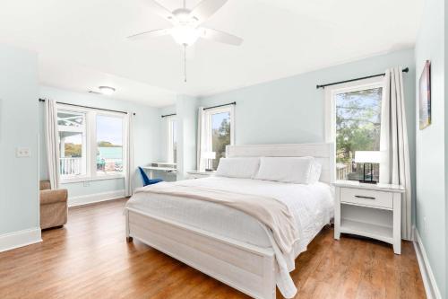 een witte slaapkamer met een bed en 2 ramen bij Village Place 6B - Bella Tybee in Tybee Island