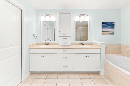 een witte badkamer met 2 wastafels en een bad bij Village Place 6B - Bella Tybee in Tybee Island