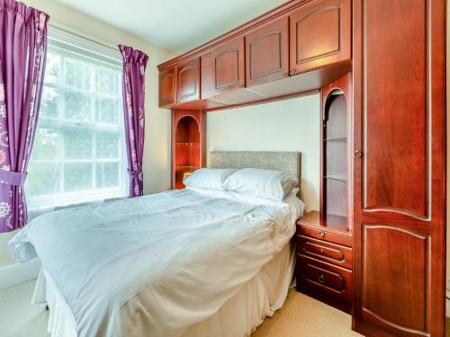ハイブリッジにあるMulberry Houseのベッドルーム1室(大型ベッド1台、木製キャビネット付)