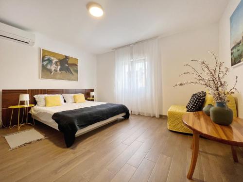a bedroom with a bed and a table in it at Apartments Teodora Maria in Novigrad Istria