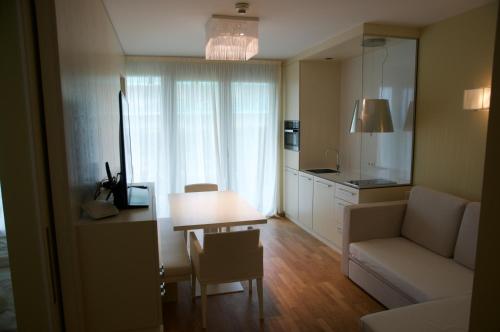 sala de estar con sofá, mesa y cocina en Nikola Luxury Apartments Senia, en Petrčane