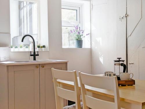 a kitchen with a table and chairs and a sink at June Cottage in Bognor Regis