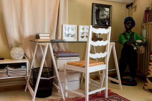 eine Puppe, die neben einem Schreibtisch und einem Stuhl steht in der Unterkunft La maison d'Huguette in Profondeville
