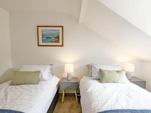 - 2 lits installés l'un à côté de l'autre dans une chambre dans l'établissement June Cottage, à Bognor Regis