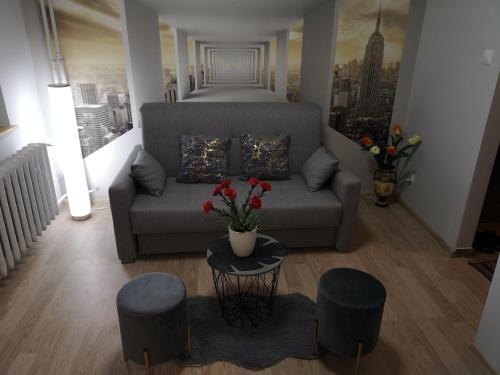 salon z kanapą i 2 stołkami w obiekcie Apartament przy dworcu w Krośnie