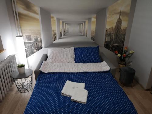 sypialnia z dużym łóżkiem z niebieską pościelą w obiekcie Apartament przy dworcu w Krośnie