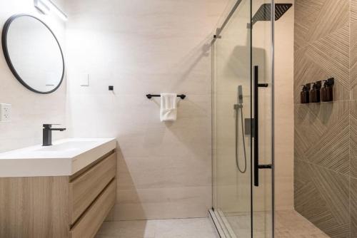 Un baño con ducha, lavabo y espejo. en Thena Hotel - Ground Floor 1 Bedroom Suite, en Filadelfia
