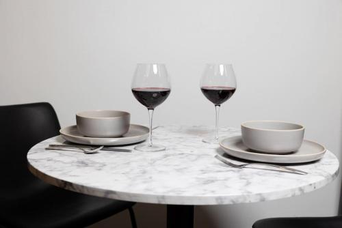 a table with two glasses of red wine on it at Thena Hotel - Ground Floor 1 Bedroom Suite in Philadelphia