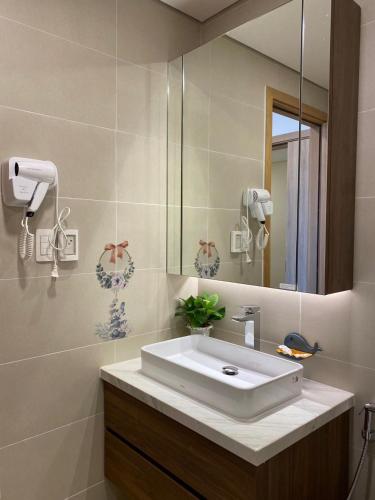 a bathroom with a white sink and a mirror at Căn hộ 5 sao tiêu chuẩn Quốc Tế rộng 95m2 ở Aria Resort Vũng Tàu in Xa Thang Nhut