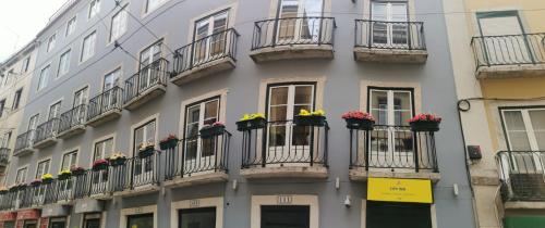 un bâtiment avec des boîtes de fleurs et des balcons. dans l'établissement CityInn Suites, à Lisbonne