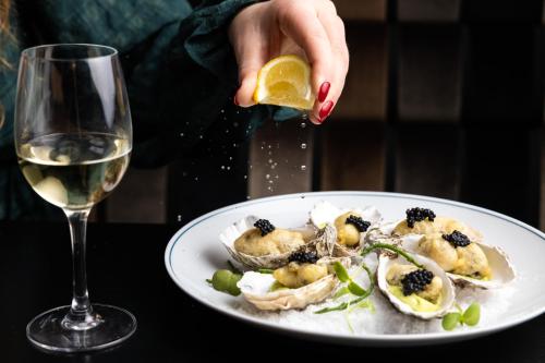 a person holding a lemon next to a plate of food at 8 Beresford Street in Saint Helier Jersey