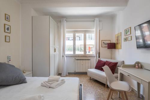 - une chambre avec un lit, un bureau et un canapé dans l'établissement Cinecittà Gem Flat with Veranda, à Rome