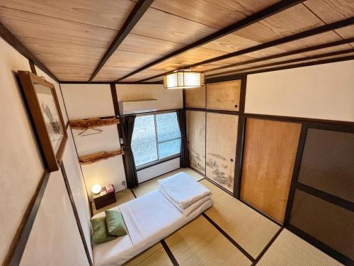 a small room with a couch and a window at Bighem Maison 2 in Izumi-Sano