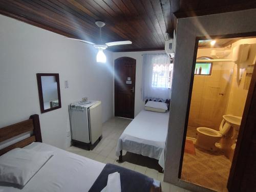 Cette petite chambre comprend 2 lits et un miroir. dans l'établissement Pousada Taquinha Paraty, à Parati