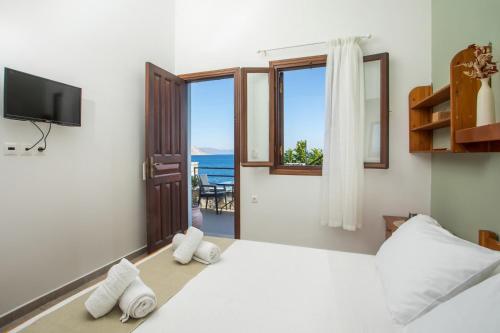 1 dormitorio con 1 cama y vistas al océano en Margaritas apartments, en Symi