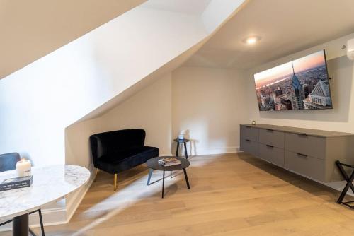 a living room with a black chair and a table at Thena Hotel - Spacious Studio in Philadelphia