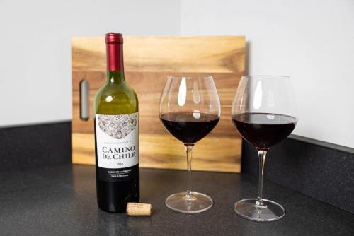 a bottle of wine and two glasses on a counter at Thena Hotel - Spacious Studio in Philadelphia