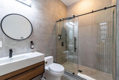 a bathroom with a shower and a toilet and a mirror at Thena Hotel - Cozy Studio in Philadelphia