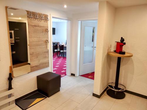 a hallway with a door to a room with a table at Wellness Hotel Garni Krone in Baiersbronn