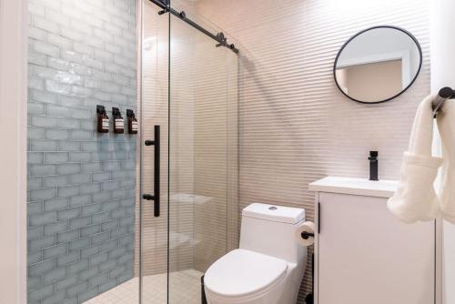 uma casa de banho com um WC e uma cabina de duche em vidro. em Thena Hotel - Beautiful 1 Bedroom em Filadélfia