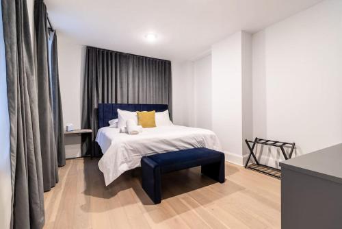 Thena Hotel - Beautiful 1 Bedroom في فيلادلفيا: غرفة نوم مع سرير ومقعد أزرق