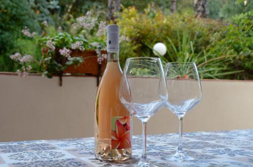 una botella de vino y dos copas de vino en una mesa en Sea Breeze Acitrezza en Aci Castello