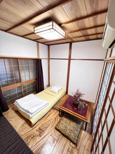 a small room with a bed and a table at Bighem Maison 2 in Izumi-Sano