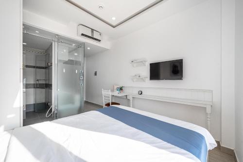 a bedroom with a bed and a tv on the wall at Cozrum Homes - Sonata Residence in Ho Chi Minh City