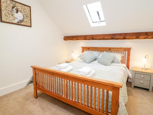 a bedroom with a large wooden bed with two towels on it at The Old Stable in Conwy