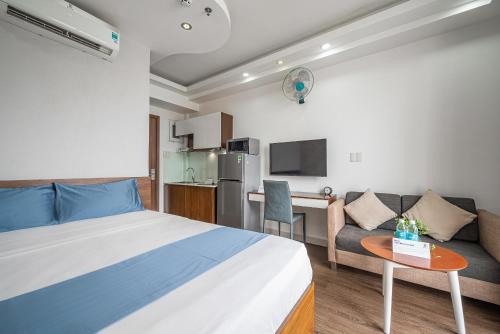 a bedroom with a bed and a couch and a table at Cozrum Homes - Sonata Residence in Ho Chi Minh City