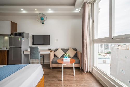 a hotel room with a bed and a table and a kitchen at Cozrum Homes - Sonata Residence in Ho Chi Minh City