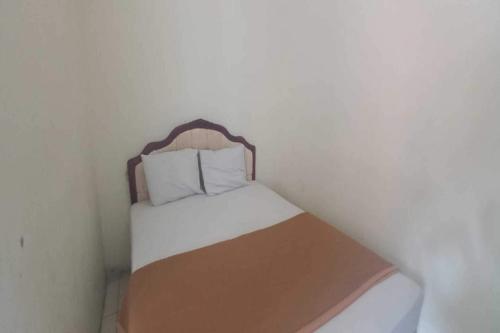SPOT ON 92434 Puri Kasih Guest House Syariah في سولو: سرير صغير في زاوية من الغرفة