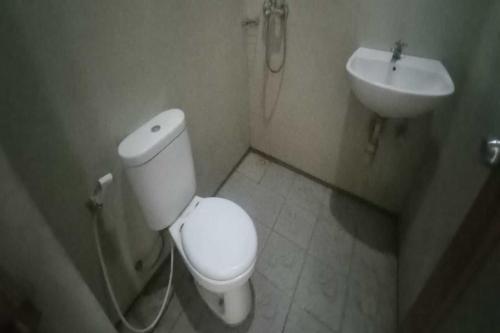 SPOT ON 92434 Puri Kasih Guest House Syariah في سولو: حمام مع مرحاض ومغسلة