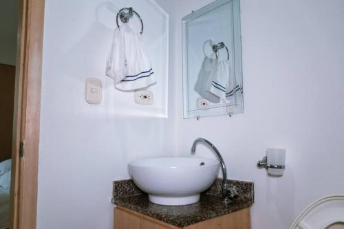 een badkamer met een witte wastafel en een spiegel bij Apartamento viajes de trabajo en el norte in Montería