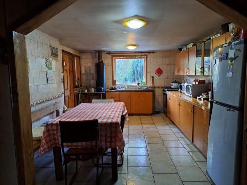 Il comprend une petite cuisine équipée d'une table et d'un réfrigérateur. dans l'établissement Hermosa cabaña en Lago Ranco, à Lago Ranco