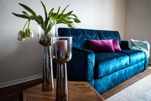 ein Wohnzimmer mit einem blauen Sofa und einem Tisch mit Brille in der Unterkunft Residence Black Eagle Lubmin Strand in Lubmin